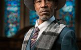 A man in a hat in a church with candles