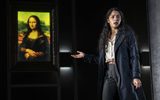 A woman gestures to a picture of the Mona Lisa