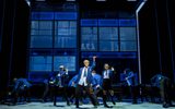 Layton Williams as Jamie strikes a pose during a dance number, dressed in school uniform. His classmate are dancing in the background