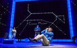 a boy sits on the floor making his hands into a telescope