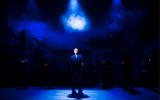 One man stands in dark blue light