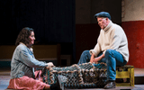 A man and a woman sit with some fishing traps