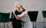 Two women looking distressed embrace