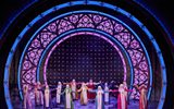 The company of Sister Act dress in colourful, sparkly habit costumes stand on stage