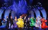 The cast of Strictly Ballroom: The Musical dressed in flamboyant brightly coloured dresses and smart black suits