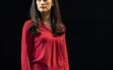 A female character in a pink blouse looks worriedly over her shoulder.