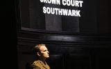 A man wearing army uniform sits beneath a sign reading 'Crown Court Southwark'.