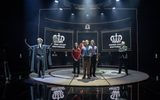 The cast of Quiz stand in front of digital screens which read 'Crown Court Southwark'.