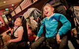 Two girls in wheelchairs, one is laughing.