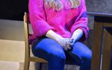 Kym Marsh as Rachel, sitting on a chair in blue jeans and a pink jumper