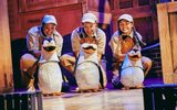 three penguin puppets controlled by three women.