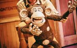 A monkey puppet controlled by a man.