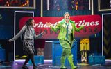 A young female wearing a school uniform dances beside a person wearing an all green flying outfit.