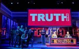 A picture of the whole stage, cast and a sign reading 'TRUTH NEWS'.