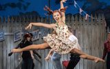 A girl in a dress leaping in the air.