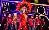 Johannes wears a large feathered headdress whilst others dance around him.