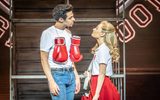 A female takes to a male with boxing gloves hanging around his neck.