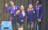 Four people wearing school uniforms pose for a photograph.