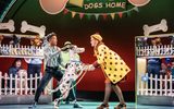 A female shakes hands with a dalmatian, in front of a sign that reads 'dog's home'.