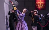 A female opens a large bottle of champagne whilst some male soldiers salute behind her.